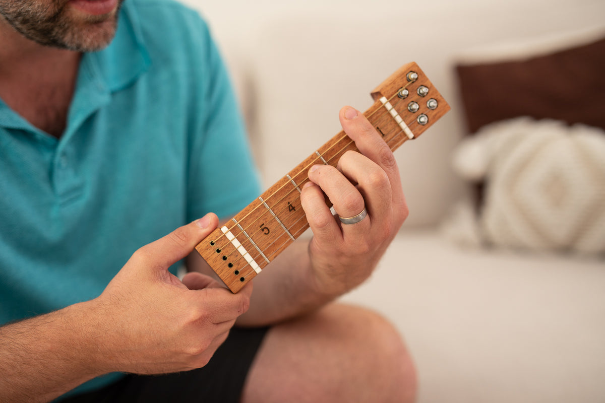 Hands practicing a chord shape on Chordly
